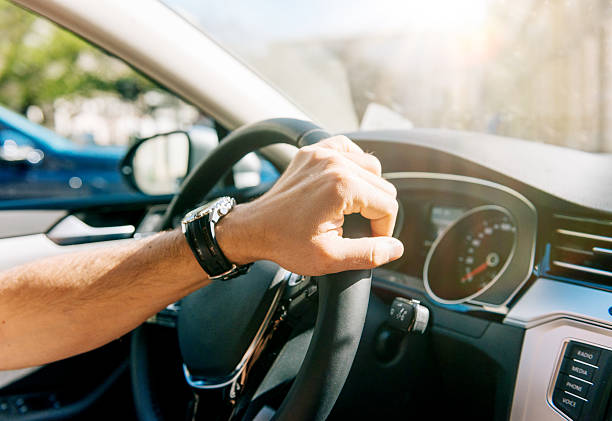 istock Man driving modern car in summer and turning steering wheel 475099572
