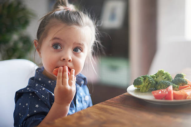 gemüse essen von kindern macht sie gesünder - baby girls stock-fotos und bilder