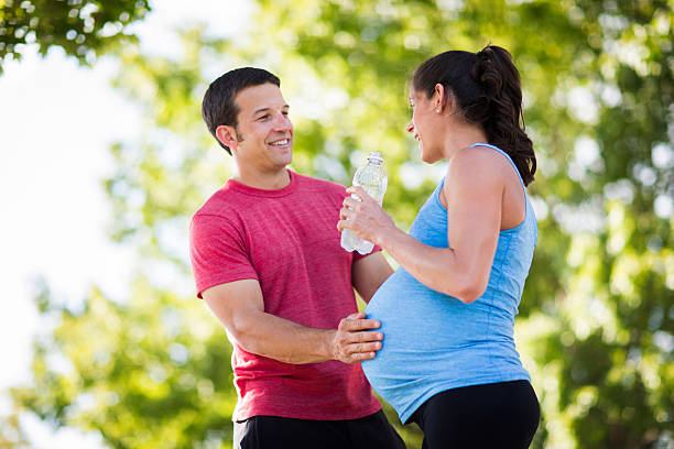 istock Pregnant woman with husband exercising. 475106036