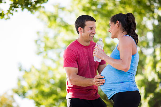 istock Pregnant woman with husband exercising. 475106040