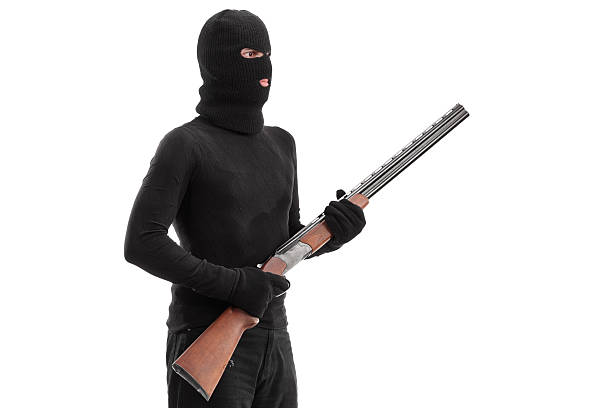 istock Dangerous criminal holding a shotgun rifle isolated on white bac 475112688