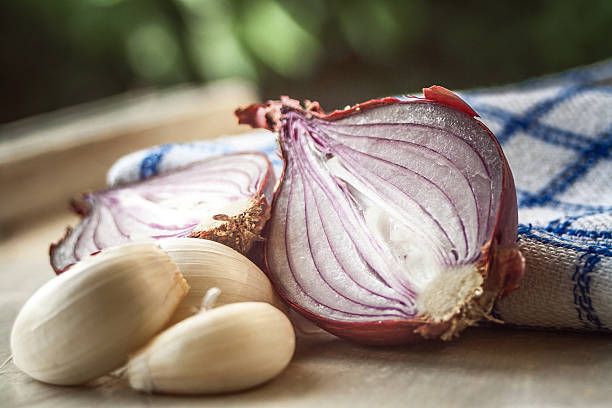 cipolla e aglio su tagliere - aglio alliacee foto e immagini stock