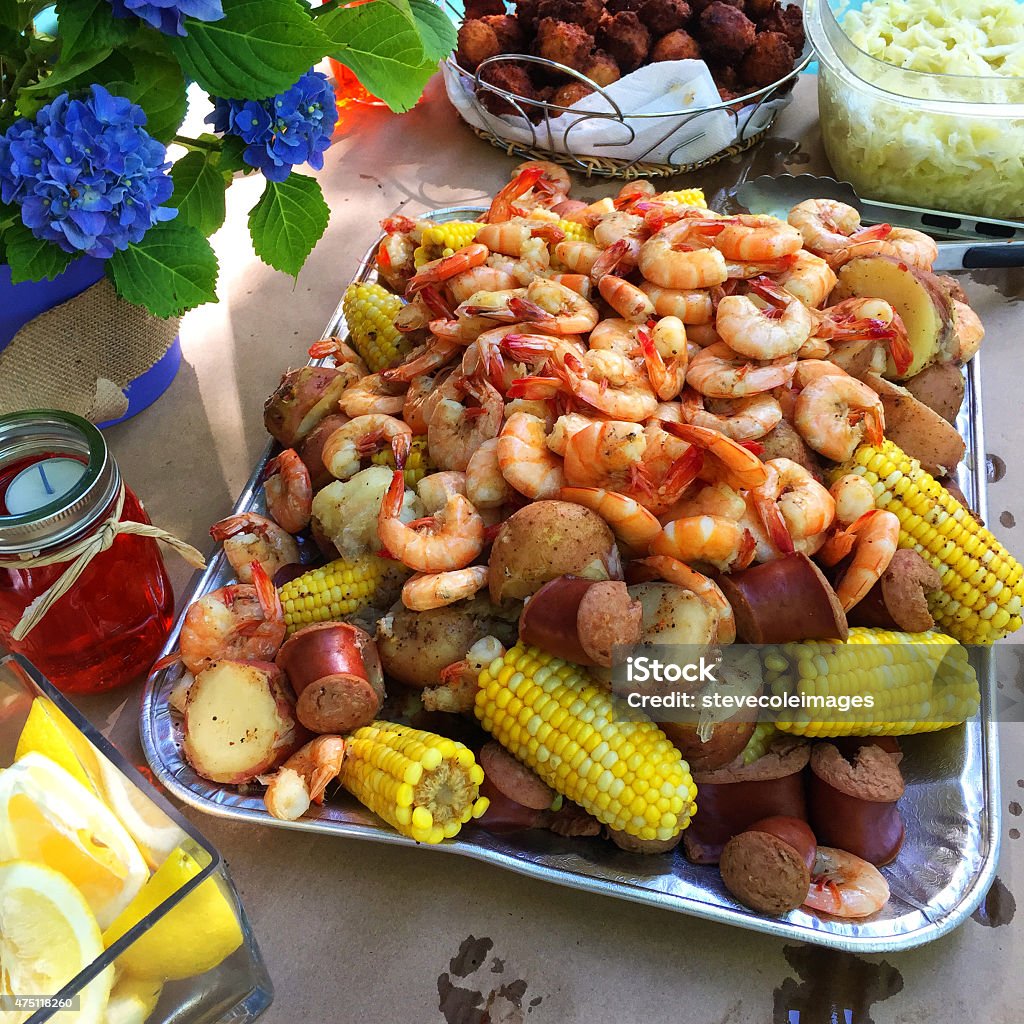 Low Country Boil Boil new potatoes being poured on corn on the cop and sausages. Low Country Boil. Boiling Stock Photo
