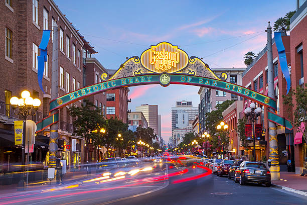 Downtown San Diego Gaslamp sign over moving traffic Downtown San Diego Gaslamp sign over moving traffic downtown district stock pictures, royalty-free photos & images