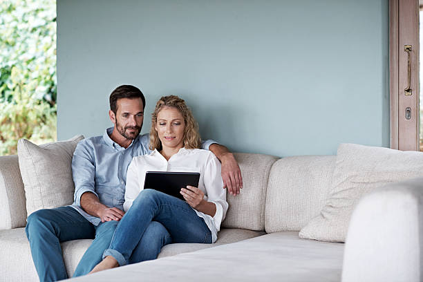 vérifier leur ensemble de médias sociaux - couple dâge moyen photos et images de collection