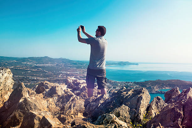 turysta ma zdjęcie, stojąc na mountain vista point - behind photographer men mountain climbing zdjęcia i obrazy z banku zdjęć