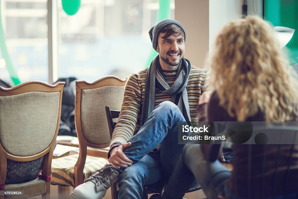 Happy man communicating with his girlfriend in a cafe. Couple communicating in a cafe. Focus is on young man. 2015 Stock Photo