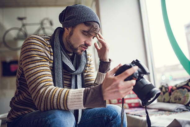 Male photographer with professional photo camera. Professional Creative approach studio yellow background. High quality photo