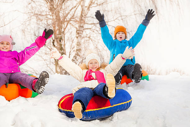 istock Children with arms high sliding down on the tubes 475129576