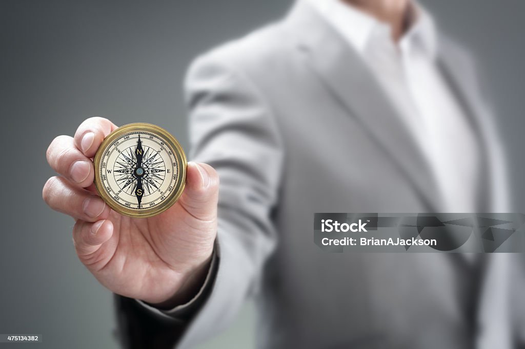 Business direction Businessman holding compass showing direction concept for guidance, strategy and business orientation Morality Stock Photo