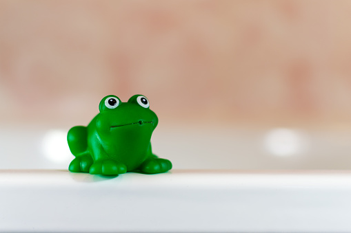 Single green plastic frog with a happy expression