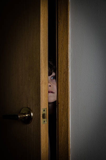 istock Boy peeking through closet door with fear 475138772
