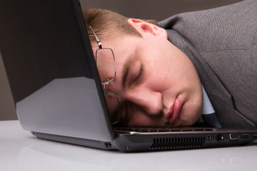 Office worker asleep on a laptop keyboard