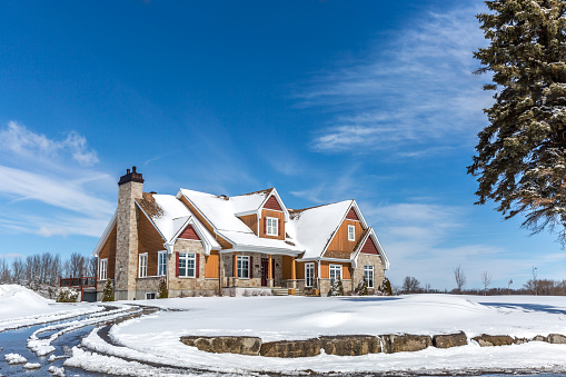 Mirabel, Canada- April 04, 2015: Luxurious wood and stone house located in Mirabel, suburb region of Montreal, during a sunny day of Spring. 