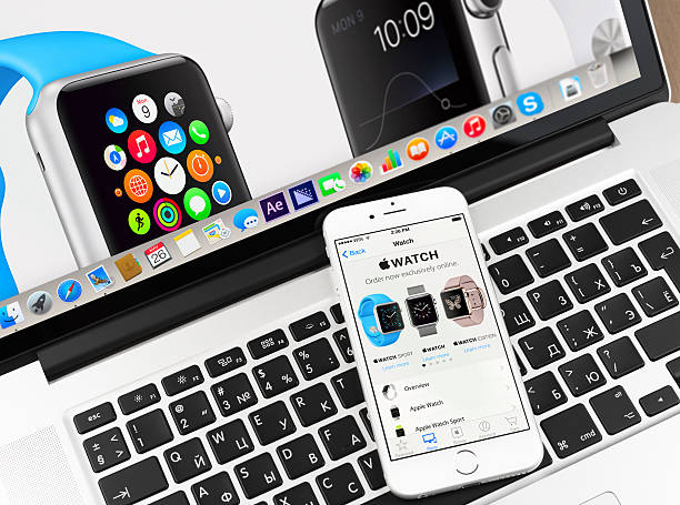 Apple watch on iPhone 6 and Macbook display stock photo