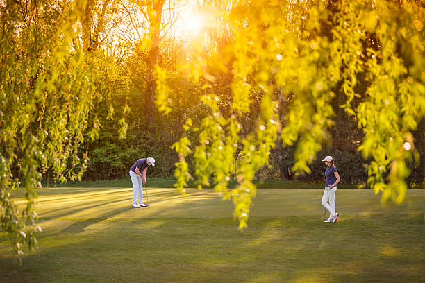 jogador de golfe casal na zona verde. - senior couple golf retirement action - fotografias e filmes do acervo