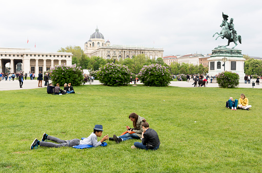 Vienna, Austria - May 1, 2015: Austrian teenagers are spending their free time on a grassy meadow in the center of Vienna, Austria.
