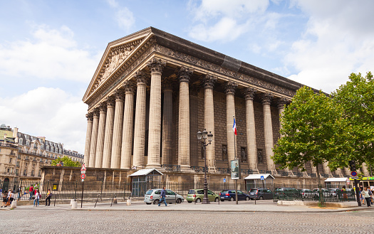 Paris, France - August 09, 2014: La Madeleine church exterior with walking tourists on the street