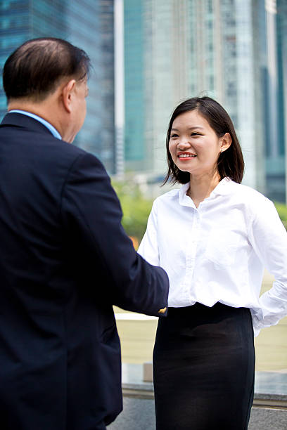 istock Asian businessman and young female shake hands 475155520