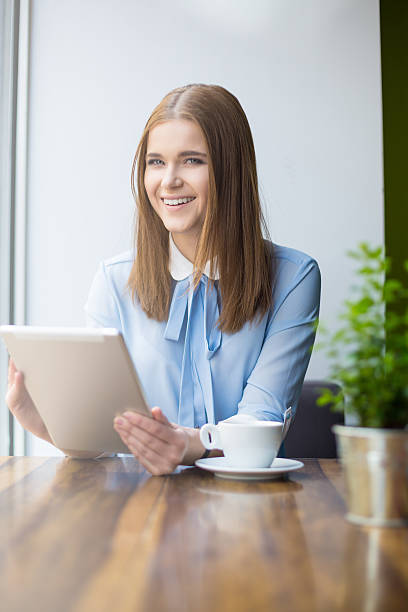 istock Smiling woman in cafe with digital tablet 475155672