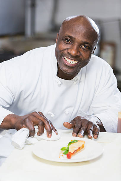 istock Black chef in a restaurant plating food 475160244