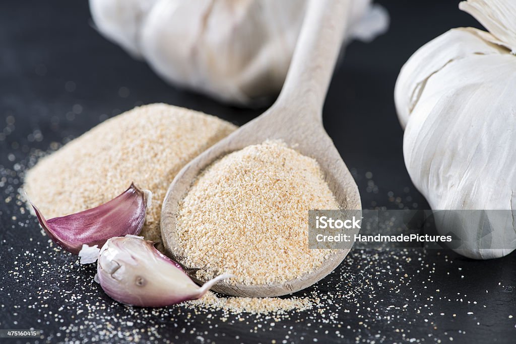 Wooden Spoon with Garlic Powder Wooden Spoon with Garlic Powder on dark background Close-up Stock Photo