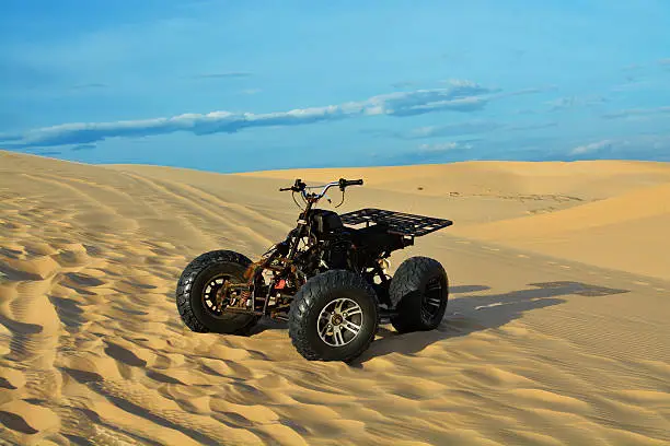 ATV in desert, White sand dunes and blue sky