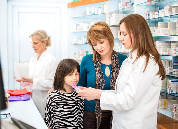 istock Pharmacist giving medication to a mother and daughter 475172404