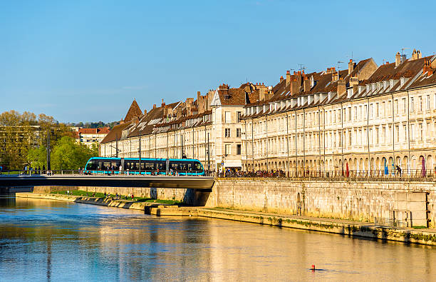 blick auf die ufer im besançon mit der straßenbahn an einer brücke - doubs river stock-fotos und bilder