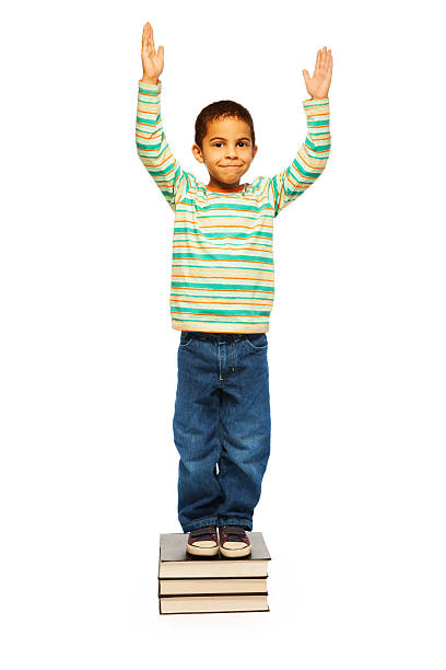Studio shot of a cute little boy jumping for joy against a white background
