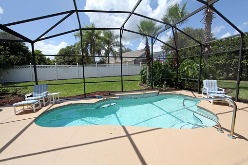 A swimming pool and deck with screen