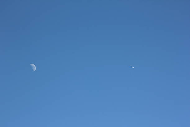 Blue Clear Sky, White Moon and Aircraft Aircraft will pass the white moon during a day with a clear blue sky. contrail moon on a night sky stock pictures, royalty-free photos & images