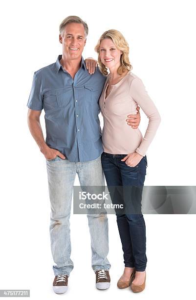 Mature Couple Standing With Hands In Pockets Stock Photo - Download Image Now - Couple - Relationship, White Background, Mature Couple