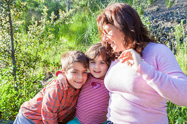 istock Mother Embracing Her Son and Daughter 475177260