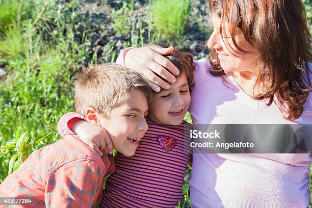 Mother Embracing Her Son And Daughter Stock Photo - Download Image Now - 2015, Adult, Affectionate