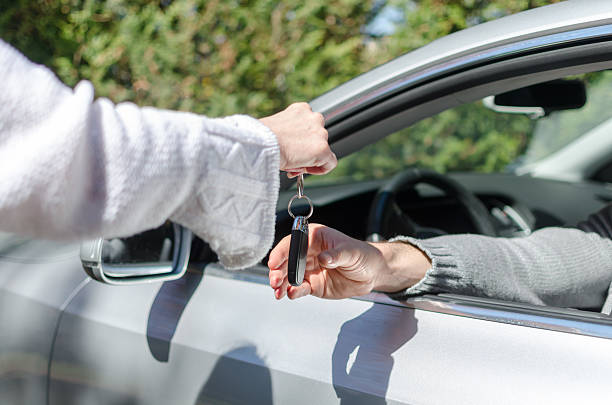 istock Woman giving car key to a man 475177680