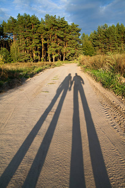 istock Shadow of two people in love at sunset 475182402