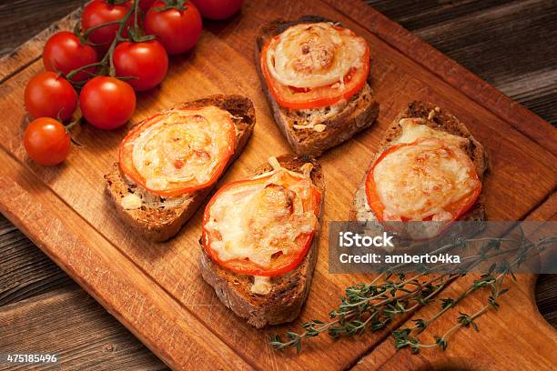 Delicious Bruschetta With Tomatoes On Cutting Board Stock Photo - Download Image Now