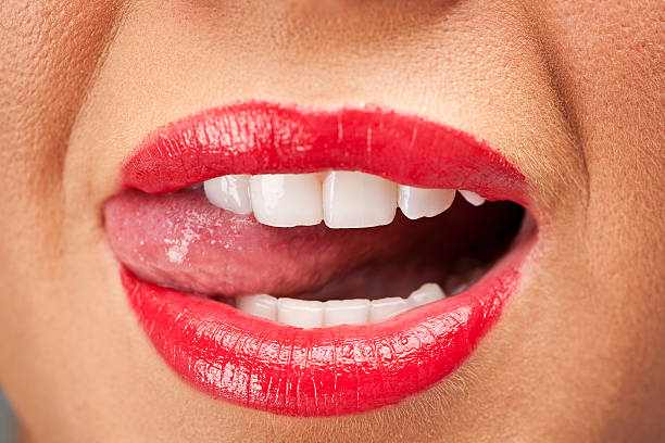istock Women licking her teeth with bright red lipstick 475187150