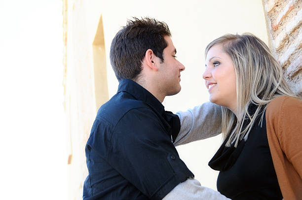 istock Flirting couple against a brick wall in park bottom view 475188340