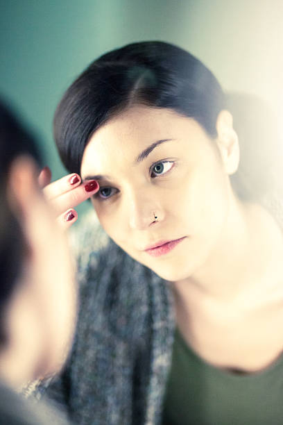 istock Beautiful young woman checking make up at the mirror 475189035