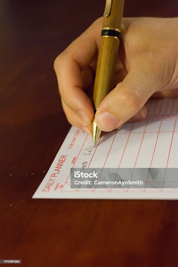 Man holding pen writing professional business man holding pen writing his to do list for the day 2015 Stock Photo