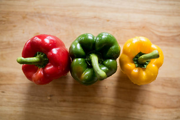 istock multicoloured peppers on wooden cutting baord 475194642