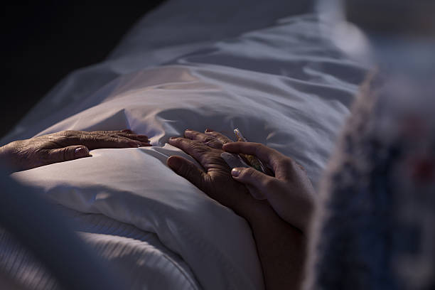 Terminally ill patient Terminally ill patient and assisting family member night hospital bed stock pictures, royalty-free photos & images