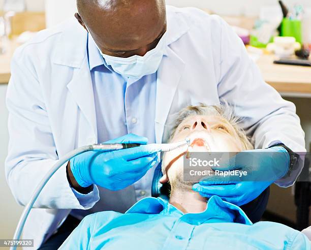 Dentist Drills A Male Patients Teeth Stock Photo - Download Image Now - 20-29 Years, 2015, Adult