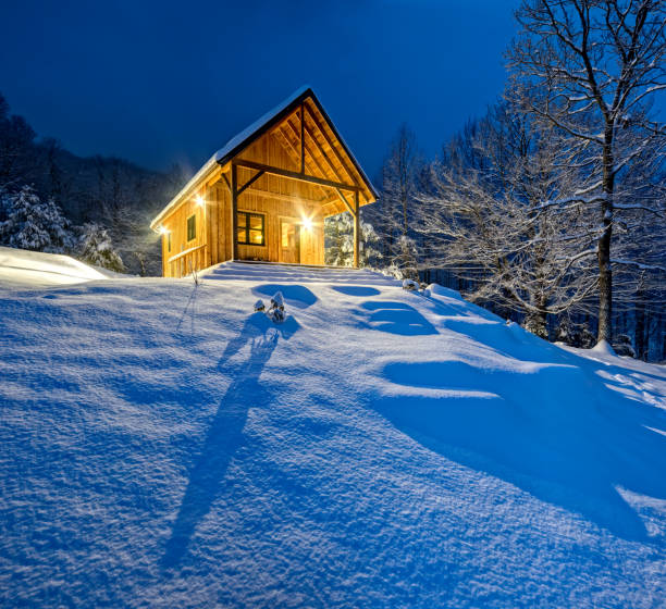 istock Rustic cabin in winter blizzard snowstorm at night 475203169