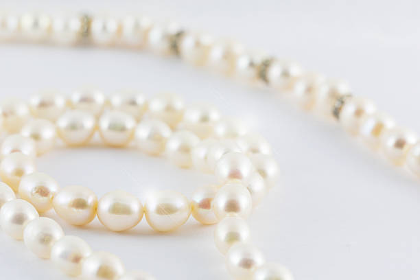 istock Beautiful creamy pearls necklace curve isolated on white backgro 475204932