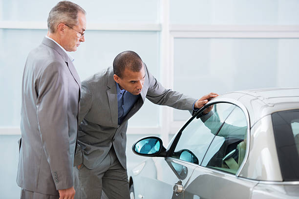 istock Two businessman examining new car. 475205612