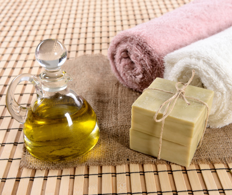 Spa products, olive oil, soap and bath towel.