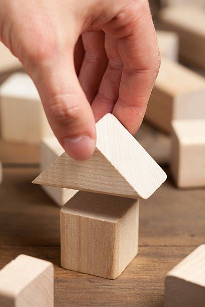 istock Wooden toy house with hand on old table 475211682
